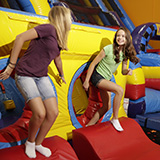 Two kids jumping on a bounce house