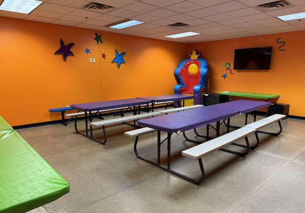 Pump It Up Eden Prairie MN party room with picnic tables, an inflatable throne where kids eat pizza and eat cake during a kids birthday party