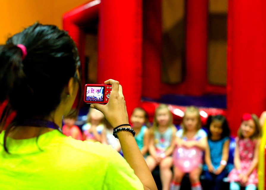 Pump It Up staff taking a group photo of kids in the birthday party arena space.